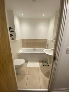 y baño con bañera, aseo y lavamanos. en Rueben Suite By Koya Homes - Cardiff, en Cardiff