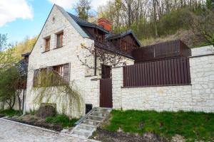 a white brick house with a fence on a hill at Domek Prezesa in Kazimierz Dolny