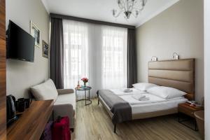 a bedroom with a bed and a couch and a television at Grodzka Royal Apartments in Krakow