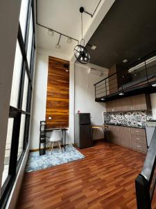 a living room with a wooden floor and a large window at liora Cambodia - Riverside Loft Apartments in Phnom Penh