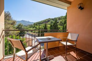 Un balcón con 2 sillas y una mesa con vistas. en Hotel Yacht Club, en Marciana Marina