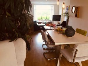a room with a table and chairs and a large plant at Beautiful house at beach, sea and dunes in Wijk aan Zee
