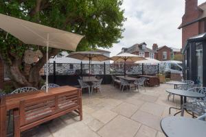 a patio with tables and chairs and umbrellas at Florence Suite Boutique Hotel and Restaurant in Portsmouth
