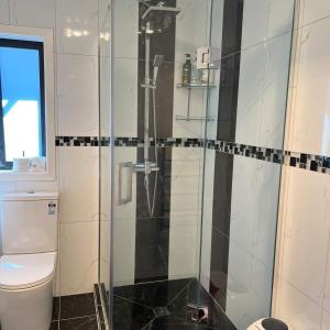 a bathroom with a shower and a toilet at Beautiful 2 Bedroom Home in Auckland