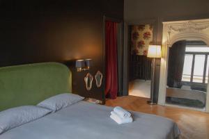 um quarto com uma cama com uma toalha em La Maison du Théâtre em Ravenna