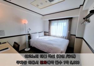 a bedroom with a bed and a desk and a window at Toyoko Inn Incheon Bupyeong in Incheon