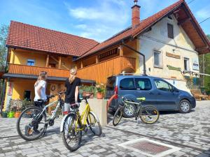 three people standing with their bikes in front of a house at Tomas Old House - River Apartments in Visoko