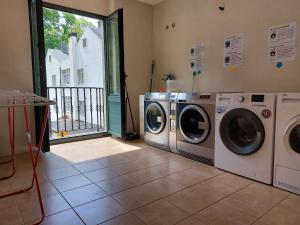 uma lavandaria com duas máquinas de lavar roupa e uma janela em Hospedería Externa del Monasterio em Samos