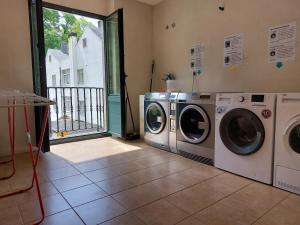 a laundry room with two washing machines and a window at Hospedería Externa del Monasterio in Samos +9 photos