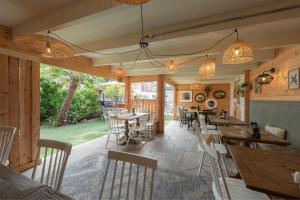 a restaurant with wooden walls and tables and chairs at Florence Gardens Boutique Hotel and Restaurant in Portsmouth