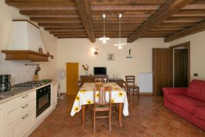 a kitchen and living room with a table and a red couch at Oleandro in Santa Luce