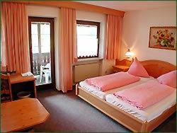 a bedroom with a large bed and two windows at Landgasthof Neitsch in Schwarzenberg