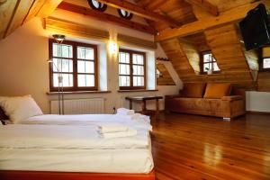 Cette grande chambre comprend deux lits et un canapé. dans l'établissement Domek Prezesa, à Kazimierz Dolny