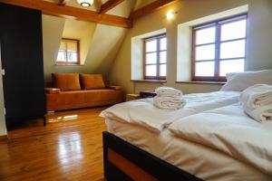 two twin beds in a room with a couch at Domek Prezesa in Kazimierz Dolny