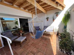 eine Veranda mit einer schwingenden Hängematte auf einem Haus in der Unterkunft La Tejita Holiday House in La Tejita