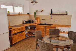 a kitchen with a table and some chairs and a refrigerator at La Tejita Holiday House in La Tejita