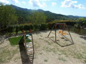 dos columpios en un patio con montañas en el fondo en Masía Puigadoll, en Rodonyà