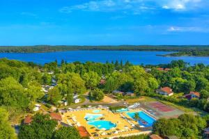 Camping 4 étoiles DOMAINE D'EUROLAC في Aureilhan: اطلالة جوية على منتجع مع مسبح وبحيرة