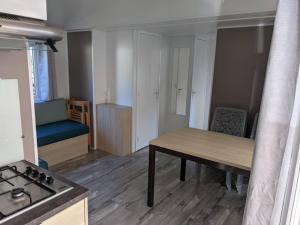 une petite cuisine avec une table et une cuisinière dans l'établissement Camping 4 étoiles RIVAGES DES LANDES anciennement Domaine Eurolac, à Aureilhan 4 autres photos