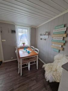 a dining room with a table and chairs and a window at Hytte på vakre kolberg. in Sylte