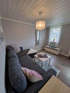 sala de estar con sofá y mesa en Hytte på vakre kolberg., en Sylte