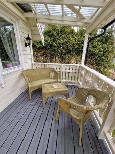 une terrasse couverte avec des chaises en osier, une table et des chaises dans l'établissement Hytte på vakre kolberg., à Sylte