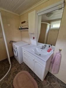 uma casa de banho com um lavatório, um WC e um espelho. em Hytte på vakre kolberg. em Sylte