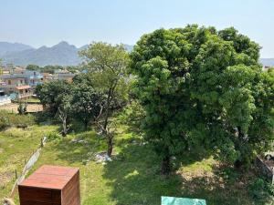 a wooden box in a field next to a tree at Bisht Niwas Homestay in Kotdwāra