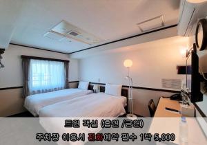 a hotel room with two beds and a window at Toyoko Inn Incheon Bupyeong in Incheon