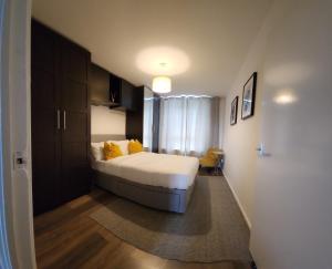 ein Schlafzimmer mit einem Bett mit gelben Kissen in der Unterkunft Your home from home in London