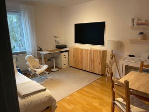 a living room with a desk and a television on a wall at Geschmackvoll eingerichtete Wohnung in Braunschweig in Braunschweig