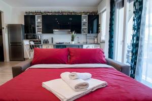 a red bed with two towels on top of it at [near Orio center]2BR The quiet and relaxing house in Azzano San Paolo