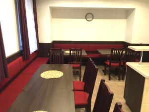 a dining room with a table and chairs and a clock at Penzion Budopartner in Jívka
