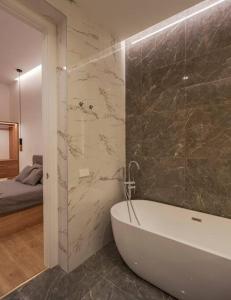 a bathroom with a bath tub and a bedroom at Luxury flat Centro I in Madrid