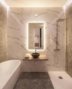 a bathroom with a tub and a sink and a mirror at Luxury flat Centro I in Madrid