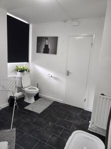 a white bathroom with a toilet and a window at Your home from home in London