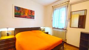 ein Schlafzimmer mit einem orangenen Bett und einem Fenster in der Unterkunft Ca' Rosin Meolo - Camera tra relax e privacy in Meolo