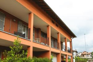 ein orangefarbenes Gebäude mit Balkon an der Seite in der Unterkunft Agriturismo Familiare I Giardini del Lago in Varese