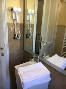 La salle de bains est pourvue d'un lavabo, d'un miroir et de serviettes. dans l'établissement Casa Rossa, à Portovenere
