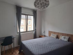 sypialnia z łóżkiem, oknem i krzesłem w obiekcie Confortable maison de vacances 3 étoiles, 6p w mieście Ploeren