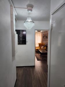 a hallway with a living room and a chandelier at Your home from home in London