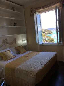 a bedroom with a large bed with a large window at Casa Rossa in Portovenere