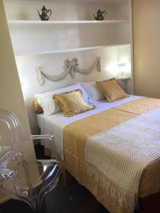 a bedroom with a bed with a headboard and a chair at Casa Rossa in Portovenere