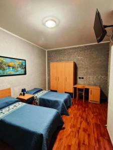 a room with two beds and a tv on the wall at AFFITTACAMERE DOLCE SOGNO in Cherasco