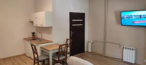 Habitación pequeña con mesa y TV en la pared. en Apartamenty ,,Pod Klonem'', en Sandomierz
