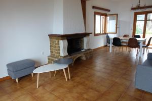 a living room with a fireplace and a table and chairs at Villa in Kalloni direkt am Meer, tolle Aussicht in Kalloni