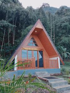 a small house with a large window and a deck at Popitan Garden Campground & Glamping Bedugul in Bedugul