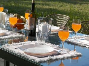 una mesa con copas de zumo de naranja y una botella de vino en Domek w lesie Puszcza Zielonka en Kiszkowo