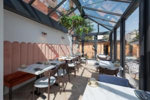 a dining room with tables and chairs and windows at Stattons Boutique Hotel & Restaurant in Portsmouth