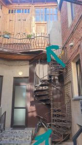 a spiral staircase leading to a building with a balcony at Mikhail Zandukeli 34 Studio in Tbilisi City